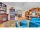 Bright living room with fireplace, bookshelves, and blue armchairs provides a comfortable space for relaxing and entertaining at 5349 Everwood Run, Sarasota, FL 34235