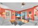 Inviting living room with orange walls, white sofas, and beach-themed accents providing a cozy and relaxing atmosphere at 5349 Everwood Run, Sarasota, FL 34235