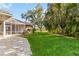 Lush backyard with a screened lanai, patio area, and a vibrant green lawn at 5401 Oak Grove Ct, Sarasota, FL 34233
