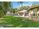 Expansive backyard with a patio, a screened-in lanai, and lush green lawn at 5401 Oak Grove Ct, Sarasota, FL 34233