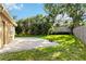 Landscaped backyard featuring a paver patio, green grass, and mature trees at 5401 Oak Grove Ct, Sarasota, FL 34233