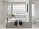 Bright bathroom with a tub, shower with glass enclosure, and a privacy window at 5401 Oak Grove Ct, Sarasota, FL 34233