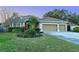 Beautiful home featuring a three-car garage, a well-manicured lawn, and a tile roof at 5401 Oak Grove Ct, Sarasota, FL 34233