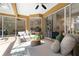 Bright sunroom features comfortable seating, a ceiling fan, and sliding glass doors to the main house at 5401 Oak Grove Ct, Sarasota, FL 34233