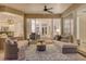 Well-lit sunroom showcasing comfortable lounge furniture, ceiling fan, and glass doors to interior living spaces at 5401 Oak Grove Ct, Sarasota, FL 34233