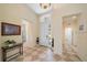 Inviting foyer features neutral paint, and tiled floors with a decorative light fixture and front door at 5508 Whitehead St, Bradenton, FL 34203