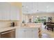 Bright kitchen features white cabinetry, modern appliances and leads into the open concept living area at 5508 Whitehead St, Bradenton, FL 34203