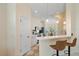 Well-lit kitchen featuring white cabinets, stainless steel appliances, and bar seating overlooking a dining area at 5508 Whitehead St, Bradenton, FL 34203