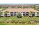 Rear aerial view of condo building featuring screened in balconies overlooking landscaped grounds at 5528 Palmer Cir # 104, Bradenton, FL 34211