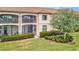 Exterior view of a two story condo with a screened balcony and well-manicured lawn at 5528 Palmer Cir # 104, Bradenton, FL 34211