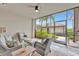 Comfortable screened-in lanai with brick floors and plush seating to enjoy the tropical outdoors at 5528 Palmer Cir # 104, Bradenton, FL 34211