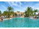 Beautiful outdoor pool featuring a rock waterfall, palm trees, and lounge chairs for relaxation at 5528 Palmer Cir # 104, Bradenton, FL 34211