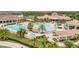 Aerial view of a community pool area with palm trees, waterfalls, and lounge chairs at 5528 Palmer Cir # 104, Bradenton, FL 34211