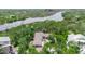 Stunning aerial view of home surrounded by lush greenery and waterfront views at 5935 River Forest Cir, Bradenton, FL 34203