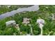 Aerial view of homes nestled among lush trees and a scenic river, highlighting the natural beauty of the location at 5935 River Forest Cir, Bradenton, FL 34203