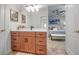 Charming bathroom with wood vanity, undermount sinks, and view to another room at 5935 River Forest Cir, Bradenton, FL 34203