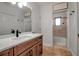 Bathroom featuring a wood vanity, marble countertop, and a view of a tiled shower through the doorway at 5935 River Forest Cir, Bradenton, FL 34203
