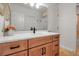 Elegant bathroom with wood vanity, marble countertop, undermount sink and a view of tiled space beyond at 5935 River Forest Cir, Bradenton, FL 34203