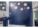 Stylish powder room boasts a unique blue pedestal sink and a dark blue textured wall with flower accents at 5935 River Forest Cir, Bradenton, FL 34203