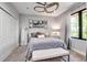 Bright bedroom featuring a neutral color palette, modern ceiling fan, carpet flooring and white closet doors at 5935 River Forest Cir, Bradenton, FL 34203