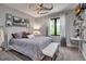 Light-filled bedroom with a contemporary ceiling fan, black framed windows, a white upholstered bench and neutral decor at 5935 River Forest Cir, Bradenton, FL 34203