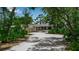 Charming single-story home nestled among mature trees with a long driveway leading up to the house at 5935 River Forest Cir, Bradenton, FL 34203