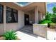 Home's welcoming covered porch with tile flooring, stone wall and view of lush landscape at 5935 River Forest Cir, Bradenton, FL 34203