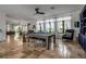 Bright, open game room with a pool table, comfortable seating and travertine flooring at 5935 River Forest Cir, Bradenton, FL 34203