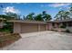 Spacious two-car garage attached to a well-maintained single-story home, set on a gravel driveway at 5935 River Forest Cir, Bradenton, FL 34203