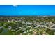 Aerial shot of the property surrounded by lush greenery, with a glimpse of the distant ocean at 5948 Mirror Lake Rd, Sarasota, FL 34238
