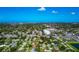Aerial view of property in a residential area with nearby lake and distant ocean view at 5948 Mirror Lake Rd, Sarasota, FL 34238