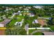 Aerial view of a property with a spacious yard, surrounded by mature trees, near a neighborhood street at 5948 Mirror Lake Rd, Sarasota, FL 34238