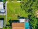A lush backyard featuring a well-maintained lawn, mature trees, and a screened-in pool at 5948 Mirror Lake Rd, Sarasota, FL 34238