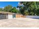 A spacious backyard featuring a concrete patio, wooden privacy fence, and a screened in room at 5948 Mirror Lake Rd, Sarasota, FL 34238