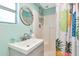 Bright bathroom featuring a vanity sink, toilet, shower, and pineapple-themed decor at 5948 Mirror Lake Rd, Sarasota, FL 34238