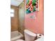 Cozy bathroom featuring a shower with tile surround and a toilet with colorful wall art at 5948 Mirror Lake Rd, Sarasota, FL 34238