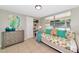 Comfortable bedroom with a daybed, tile floor, and neutral decor at 5948 Mirror Lake Rd, Sarasota, FL 34238