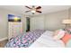 Cozy bedroom featuring a ceiling fan, white dresser, and comfortable bed with decorative pillows and a colorful comforter at 5948 Mirror Lake Rd, Sarasota, FL 34238