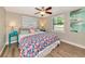 Bright bedroom with a colorful seashell themed bed set and wood flooring at 5948 Mirror Lake Rd, Sarasota, FL 34238