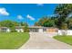 Charming single-story home with a well-manicured lawn and a long driveway leading to a screened in patio at 5948 Mirror Lake Rd, Sarasota, FL 34238
