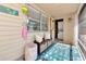 Comfortable front porch featuring bench seating with storage, a ceiling, and a view to a laundry room at 5948 Mirror Lake Rd, Sarasota, FL 34238