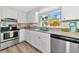 Beautiful kitchen with modern appliances, granite countertops, white cabinets, and natural light at 5948 Mirror Lake Rd, Sarasota, FL 34238