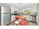 Bright kitchen featuring stainless steel appliances, white cabinetry, and a charming portable kitchen island at 5948 Mirror Lake Rd, Sarasota, FL 34238