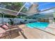 Inviting in-ground screened pool area with lounge chairs and a well-maintained deck with lush landscaping at 5948 Mirror Lake Rd, Sarasota, FL 34238