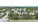 Aerial view showcasing homes, serene lake, and mature trees in a quiet residential community at 6043 44Th E Ct, Bradenton, FL 34203