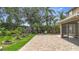 Backyard patio with brick pavers, landscaping, and screened in lanai at 6043 44Th E Ct, Bradenton, FL 34203