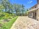 Brick paver patio overlooks a landscaped backyard with mature trees at 6043 44Th E Ct, Bradenton, FL 34203