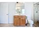 Bright bathroom featuring wood vanity, large mirror, walk-in shower, and neutral tile flooring at 6043 44Th E Ct, Bradenton, FL 34203