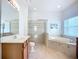 Bathroom featuring double sinks, a glass shower, and separate soaking tub at 6043 44Th E Ct, Bradenton, FL 34203