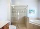 Bathroom with a glass-enclosed shower and separate soaking tub with tile surround at 6043 44Th E Ct, Bradenton, FL 34203